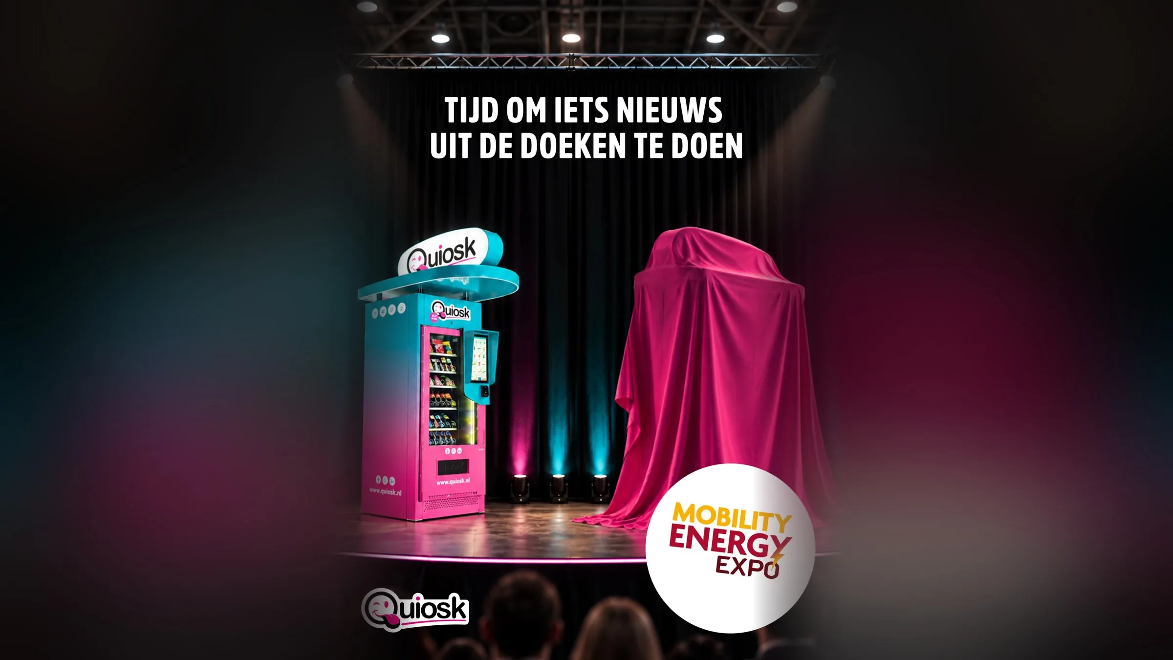 Quiosk-automaat naast een apparaat onder een roze doek op het podium: tijd om iets nieuws uit de doeken te doen op de Mobility Energy Expo